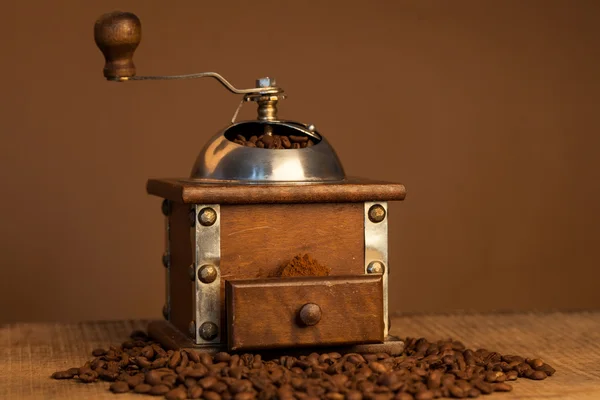 Roasted coffee beans and coffee grinder on dark background — Stock Photo, Image