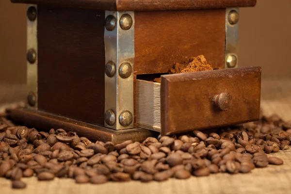Granos de café tostados y molinillo de café sobre fondo oscuro —  Fotos de Stock