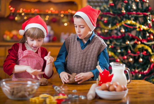 Duas crianças felizes preparando biscoito para o jantar de família na véspera de Natal — Fotografia de Stock