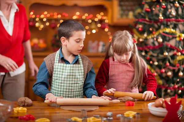 할머니와 작은 소녀와 소년 베이킹 크리스마스 일 케이크 — 스톡 사진