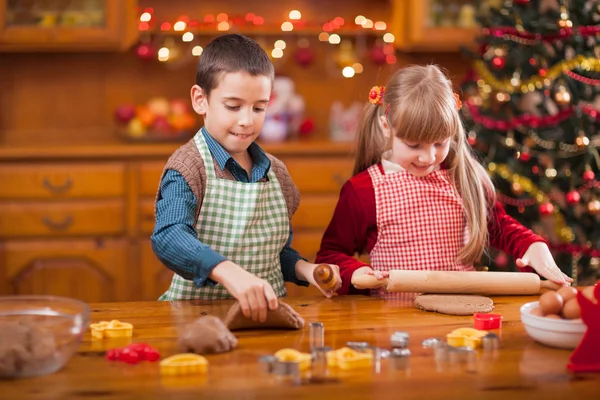 Zwei glückliche Kinder bereiten Plätzchen für Familienessen an Heiligabend vor — Stockfoto