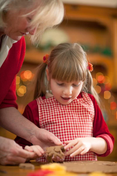 Бабушка и маленькая девочка пекут рождественское печенье — стоковое фото