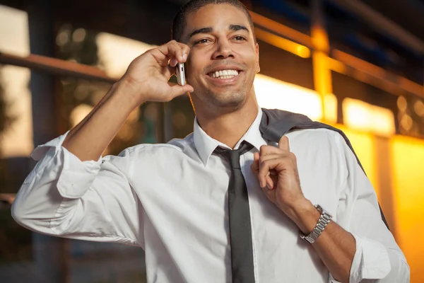 Handsome businessman talking on mobile and smiling — Stock Photo, Image