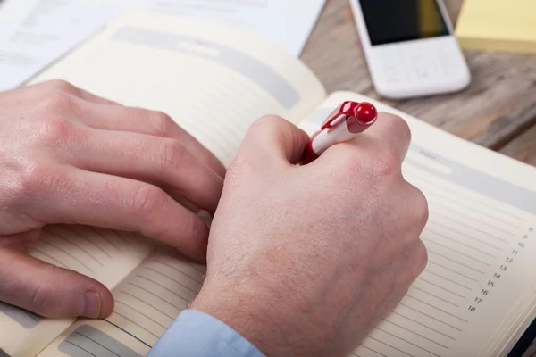 Businessman writes in a notebook — Stock Photo, Image