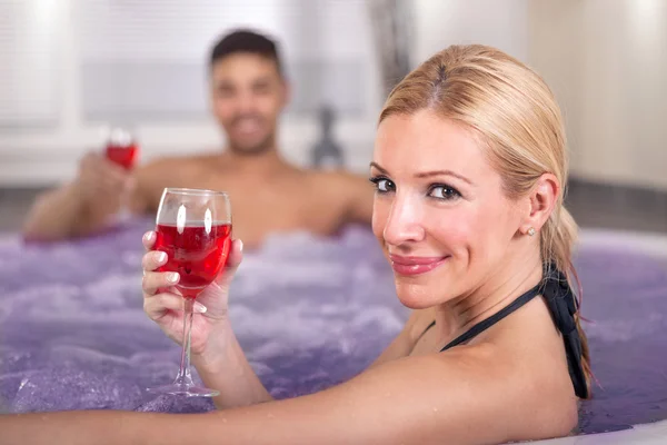 Romántica pareja bebiendo vino tinto en bañera de hidromasaje —  Fotos de Stock