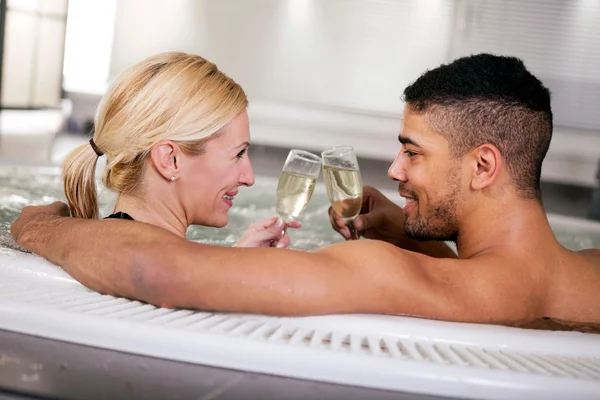 Pareja romántica beber cahmpagne en bañera de hidromasaje —  Fotos de Stock