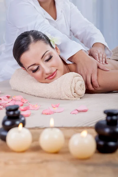 Masajista haciendo masaje en el cuerpo de la mujer en el salón de spa —  Fotos de Stock