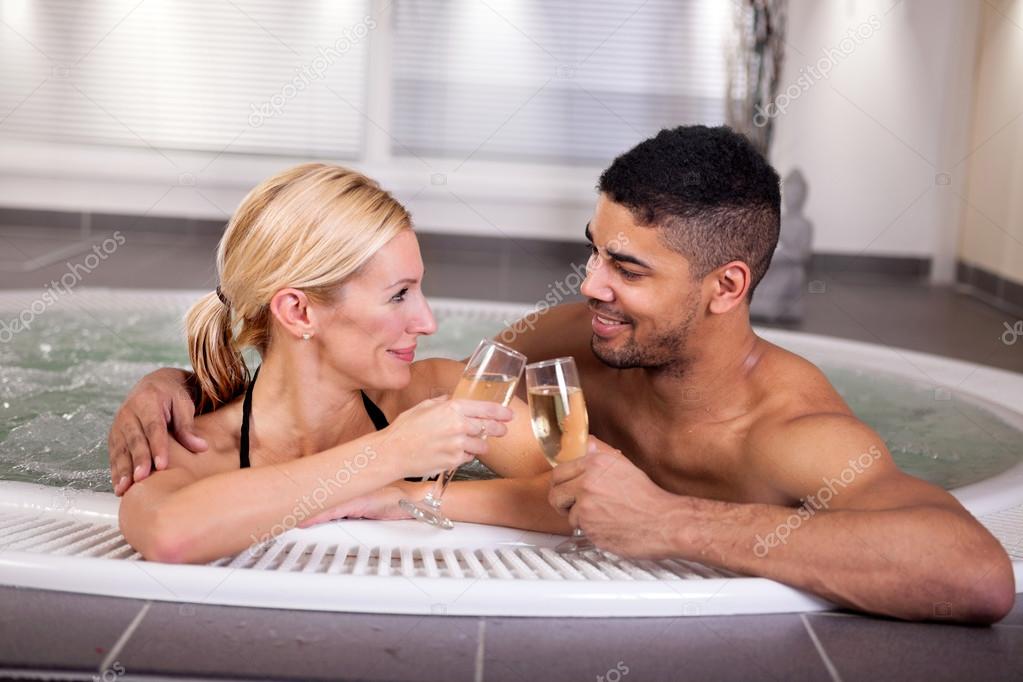 Pareja romántica beber cahmpagne en bañera de hidromasaje — Foto
