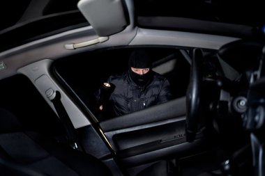 yüzünde bir maske ile hırsız pil tutar ve ne görünüyor 