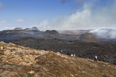 Grindavik, İzlanda - 25 Nisan 2021: Eşsiz bir doğal çekim. İnsanlar Fagradalsfall 'daki volkan patlamasını izliyor. Patlamanın 38. günü.