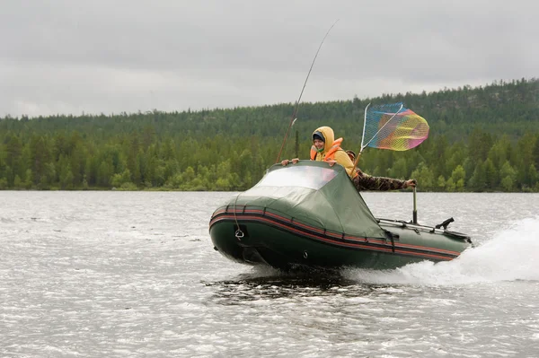 Donna galleggia barca da pesca sul lago Foto Stock Royalty Free