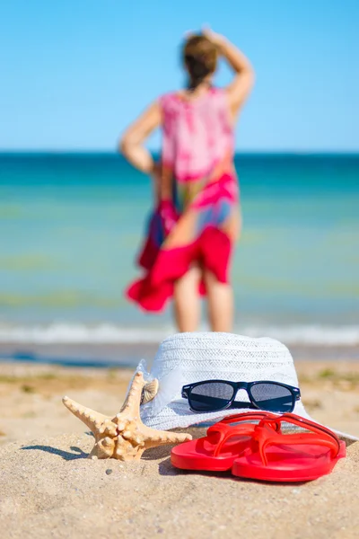 Beach accessories, woman in the background — Stock Photo, Image