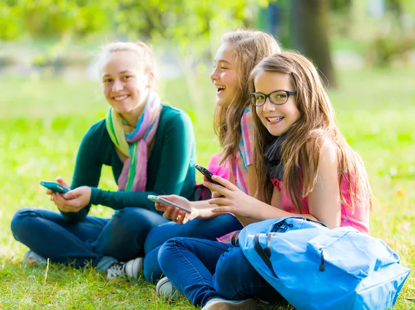 Tonåring skolflickor ha kul med mobiltelefoner — Stockfoto