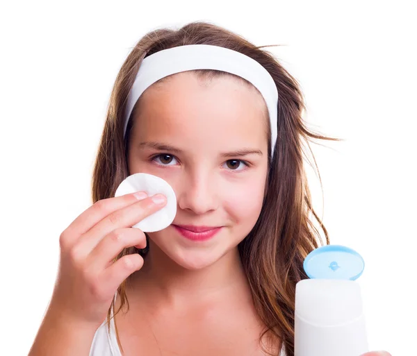 Flicka rengöring hennes ansikte med tonic lotion — Stockfoto