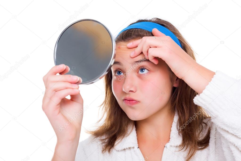 Girl examine her pimples in the mirror