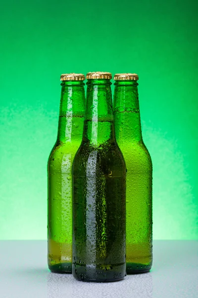 Três garrafas de cerveja molhadas em branco — Fotografia de Stock