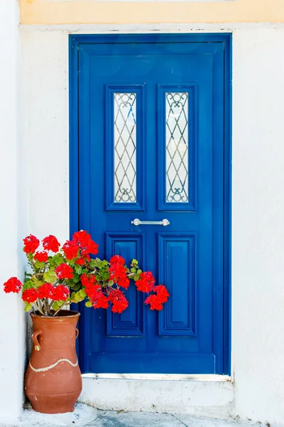 Porta da casa grega com flores de gerânio — Fotografia de Stock