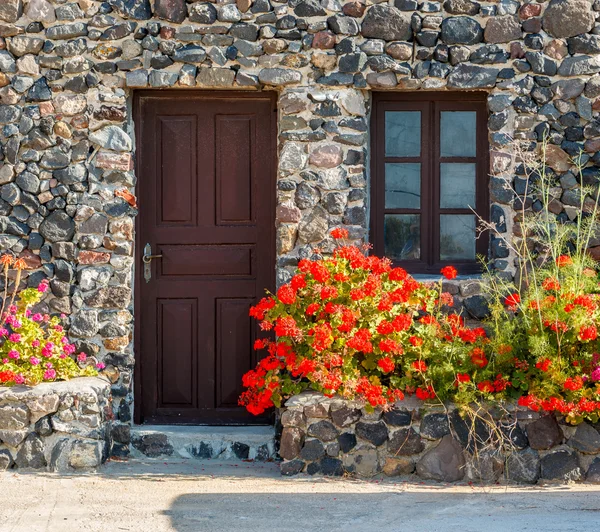 Casa de pedra grega com flores de gerânio — Fotografia de Stock