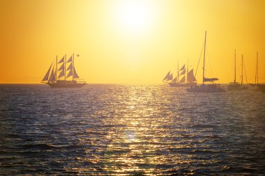 Günbatımı denizde yelkenli gemilerde