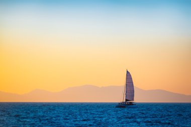 Akşam denizde yelkenli tekne