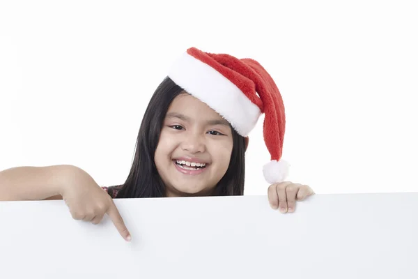 Portret Van Een Gelukkig Klein Meisje Met Kerstmuts Wijzend Een — Stockfoto