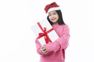 Neşeli ve mutlu Asyalı Noel kızı Noel Baba şapkası takıyor hediye kutusunu beyaz bir arka planda izole edilmiş bir şekilde elinde tutuyor.