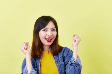 Sarı arka plan güzellik ve yüz ifadeleri üzerinde izole edilmiş kameraya gülümseyen ceketli sevimli, sevimli Asyalı genç kadın esmer.