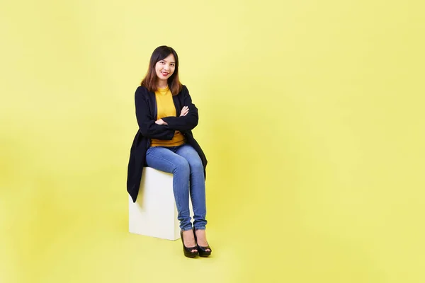 魅力的な若いアジア人女性座っています上の空白空の箱上の黄色の背景就職活動のアイデアのために — ストック写真
