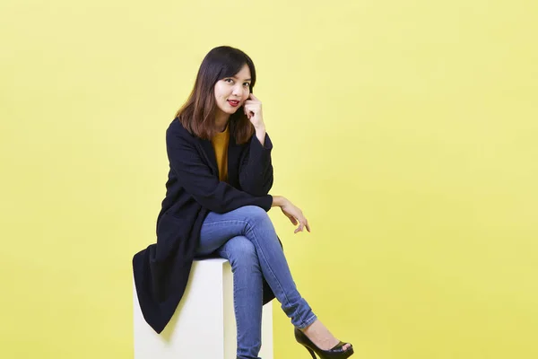 Çekici Genç Asyalı Kadın Boş Bir Kutuda Oturuyor Sarı Arka — Stok fotoğraf