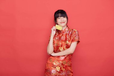 Yakışıklı Asyalı genç bir kadın Çin 'de yeni yıl için internetten Çin elbisesi ve kredi kartı alışverişi giyer.