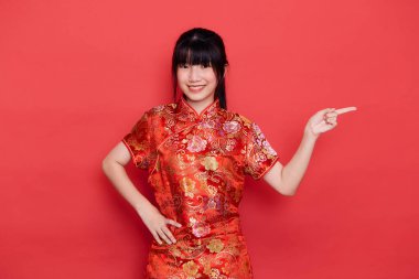 Şirin genç Asyalı kadın kırmızı arka planda Çin 'in yeni yıl konsepti için içi boş Cheongsam giyiyor.