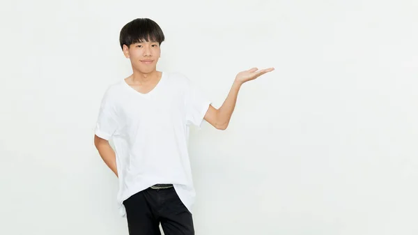 白い背景に孤立したオープンハンドジェスチャーを行うカジュアルな白いTシャツの魅力的な若いアジアの男の肖像画 — ストック写真