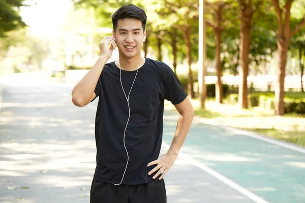 Молодий Привабливий Азіатський Чоловік Займається Вправами Вулиці Слухаючи Музику Парку — стокове фото