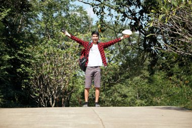 Genç hippi Asyalı bir adam yaz orman gezisi yaşam tarzı konseptiyle sırt çantasıyla seyahat ediyor.