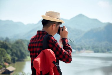 Genç hippi Asyalı bir adam yaz orman gezisi yaşam tarzı konseptiyle sırt çantasıyla seyahat ediyor.
