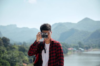 Genç hippi Asyalı bir adam yaz orman gezisi yaşam tarzı konseptiyle sırt çantasıyla seyahat ediyor.