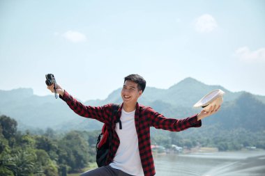 Genç hippi Asyalı bir adam yaz orman gezisi yaşam tarzı konseptiyle sırt çantasıyla seyahat ediyor.