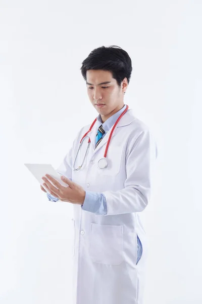 白いコートと赤い聴診器でフレンドリーなアジアの男性医師は タブレットコンピュータ 白い背景に近代的な医療技術を使用しています 医療技術の概念 — ストック写真