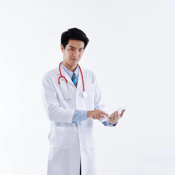 白いコートと赤い聴診器でフレンドリーなアジアの男性医師は タブレットコンピュータ 白い背景に近代的な医療技術を使用しています 医療技術の概念 — ストック写真