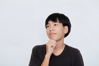 Siyah tişörtlü, gülümseyen Asyalı adam beyaz arka planda izole edilmiş kamera stüdyosuna bakıyor.