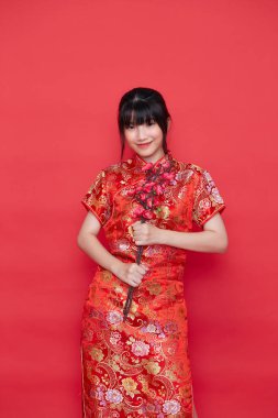 Kızıl arka planda sakura dalıyla geleneksel Çin elbisesi giymiş güzel Asyalı kadınlar, 2021 Çin yeni yılı.