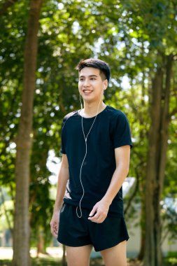 Genç Asyalı mutlu, güler yüzlü bir adam sabah dışarıda koşuyor. Fitness, spor, egzersiz ve egzersiz konsepti..