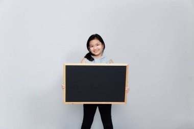 Küçük bir kız haber vermek için boş bir karatahta tutuyor. Bildirimi okuyun. Olayla ilgili bilgi. Tahtası olan tatlı bir kız öğrenci. Reklam..