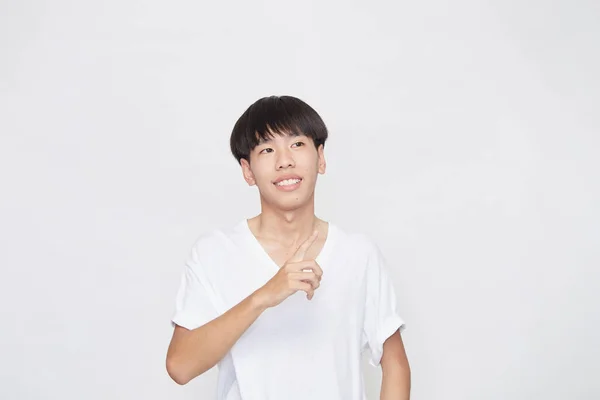 티셔츠를 공간을 가리키는 미소를 아시아 남자의 — 스톡 사진