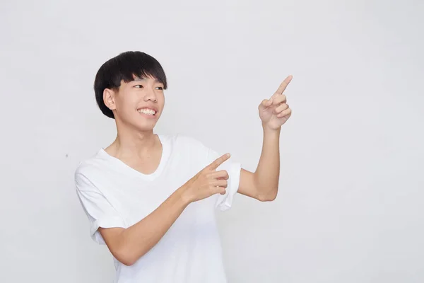 Portret Uśmiechniętego Azjaty Ubranego Biały Shirt Wskazujący Puste Miejsce Obok — Zdjęcie stockowe