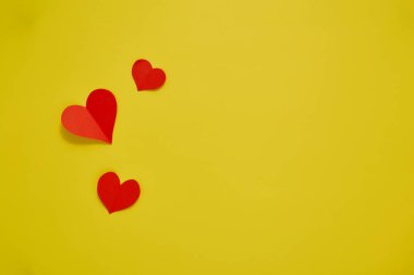 Üst görünüm Kağıt sevgililer günü kırmızı kalpler sarı zemin üzerinde Aşk kopyası alanı için kavram metin için