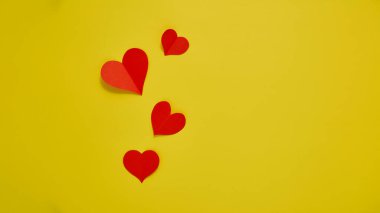 Üst görünüm Kağıt sevgililer günü kırmızı kalpler sarı zemin üzerinde Aşk kopyası alanı için kavram metin için