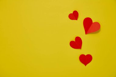 Üst görünüm Kağıt sevgililer günü kırmızı kalpler sarı zemin üzerinde Aşk kopyası alanı için kavram metin için