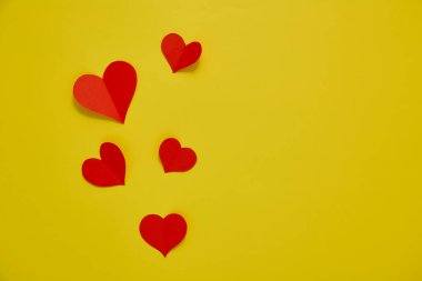 Üst görünüm Kağıt sevgililer günü kırmızı kalpler sarı zemin üzerinde Aşk kopyası alanı için kavram metin için