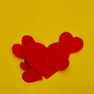 Üst görünüm Kağıt sevgililer günü kırmızı kalpler sarı zemin üzerinde Aşk kopyası alanı için kavram metin için